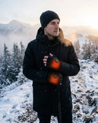 Beheizbare fingerlose Handschuhe – Mann trägt Handschuhe im Schnee
