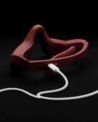 Augenmassagegerät in Brillenform – Rotes Gerät mit angeschlossenem Kabel